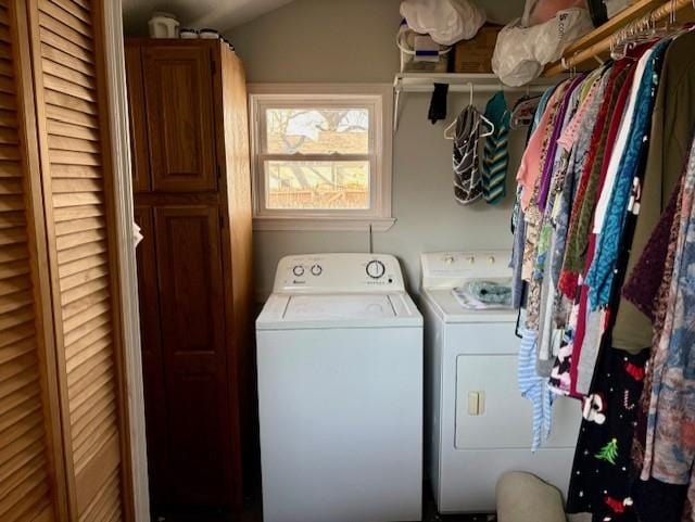 clothes washing area with washing machine and dryer and cabinet space