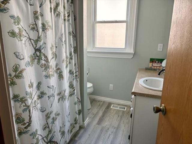 full bathroom featuring baseboards, vanity, toilet, and wood finished floors