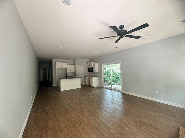 320 E 2nd St, Adrian, MO 64720 - unfurnished living room featuring dark wood-type flooring and a ceiling fan