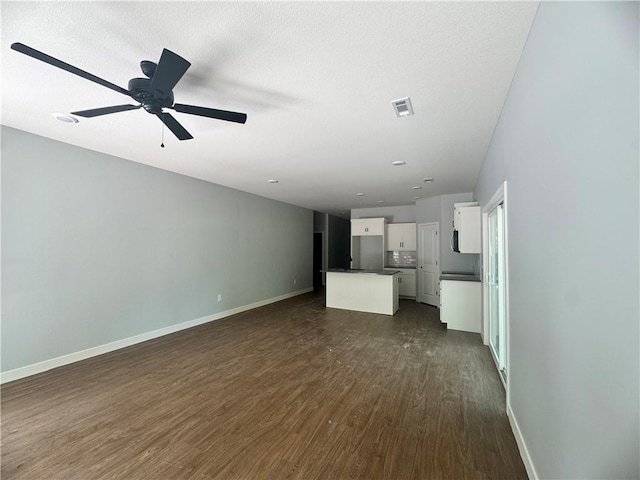 320 E 2nd St, Adrian, MO 64720 - unfurnished living room featuring dark wood finished floors and a ceiling fan