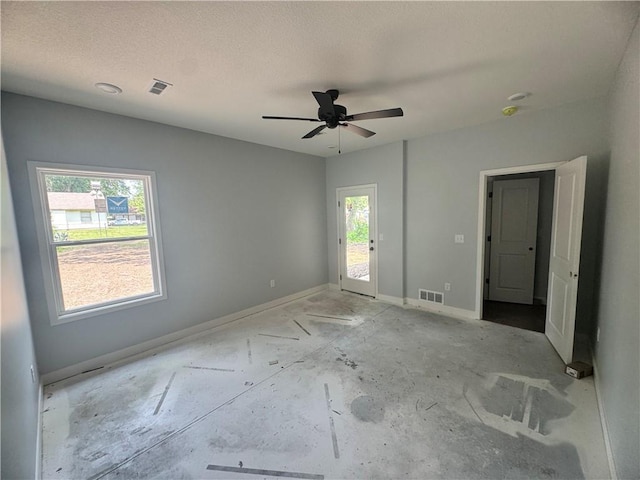 320 E 2nd St, Adrian, MO 64720 - empty room featuring healthy amount of natural light, a ceiling fan, and a textured ceiling