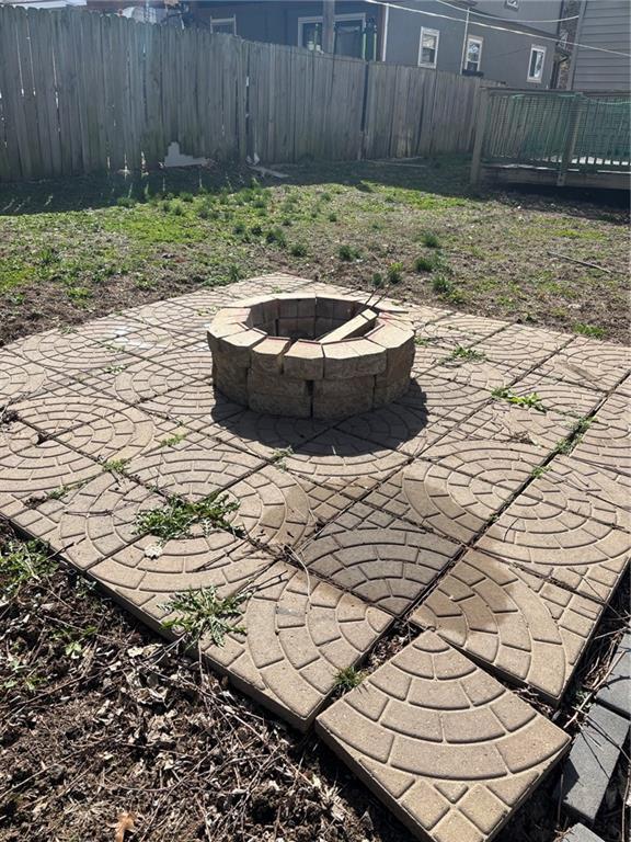view of patio with an outdoor fire pit and fence