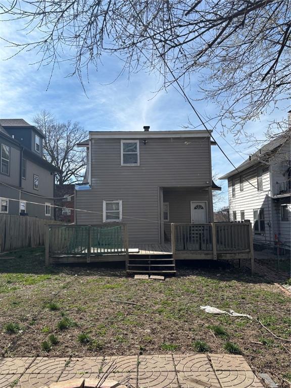rear view of house with fence and a deck