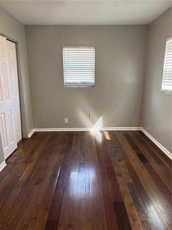 unfurnished room with hardwood / wood-style floors and baseboards