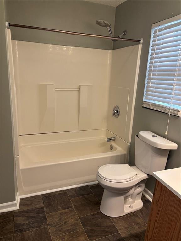 bathroom with baseboards,  shower combination, toilet, and vanity