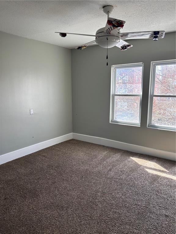 carpeted spare room with baseboards, a textured ceiling, and a ceiling fan