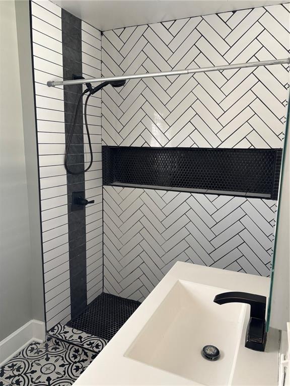 bathroom with a stall shower and a sink
