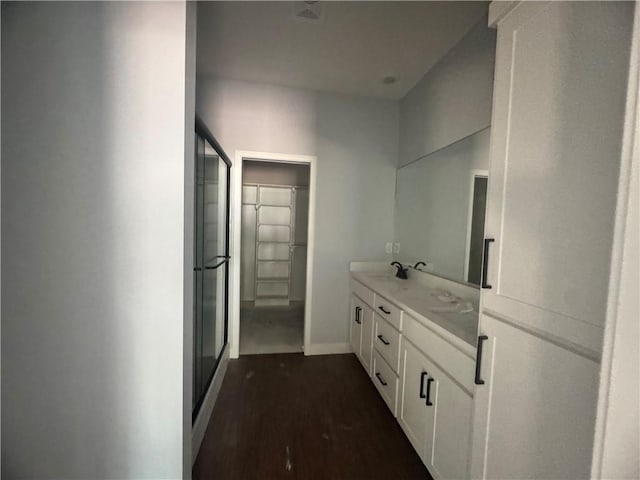324 E 2nd St, Adrian, MO 64720 - bathroom featuring double vanity, wood finished floors, a shower with door, and a spacious closet