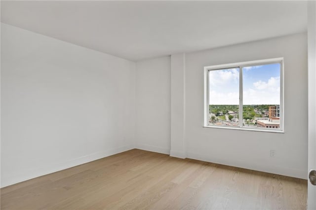 unfurnished room featuring light wood-style flooring and baseboards