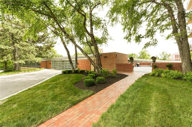 view of front of home with driveway and a front lawn