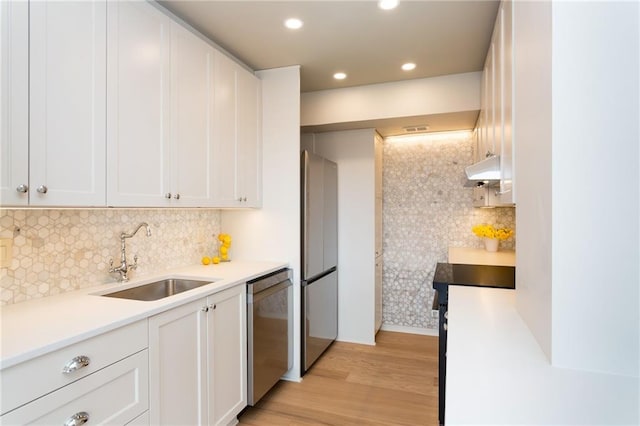 kitchen featuring a sink, light wood-style floors, stainless steel appliances, white cabinets, and under cabinet range hood