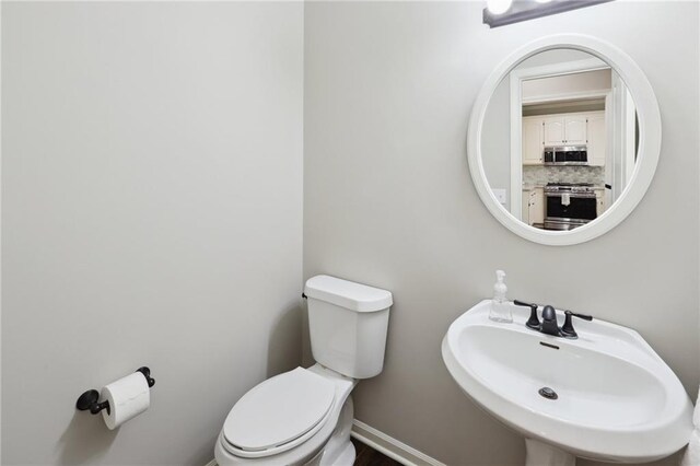 5329 Park St, Shawnee, KS 66216 - bathroom featuring toilet, a sink, and baseboards