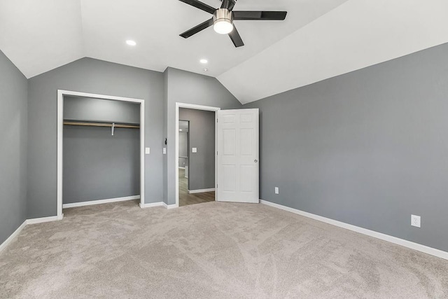 unfurnished bedroom featuring a closet, carpet floors, baseboards, and vaulted ceiling