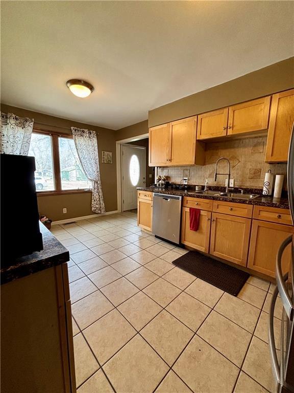 1519 Niagara St, Burlington, KS 66839 - kitchen featuring light tile patterned flooring, a sink, backsplash, dishwasher, and baseboards