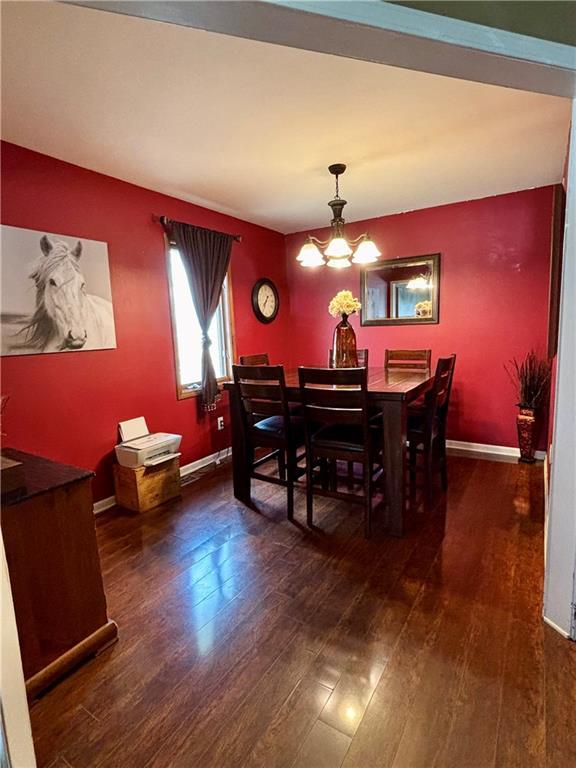 1519 Niagara St, Burlington, KS 66839 - dining room with baseboards, wood finished floors, and a chandelier