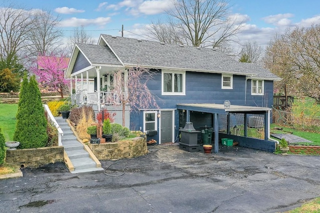 view of front of home featuring driveway and a shingled roof