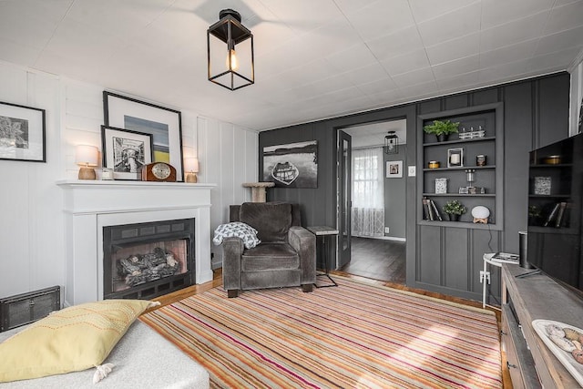 living room featuring a fireplace, visible vents, and wood finished floors