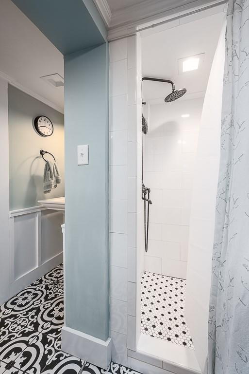 full bath with a stall shower and crown molding