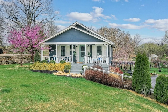 view of front of house with covered porch, fence, and a front yard