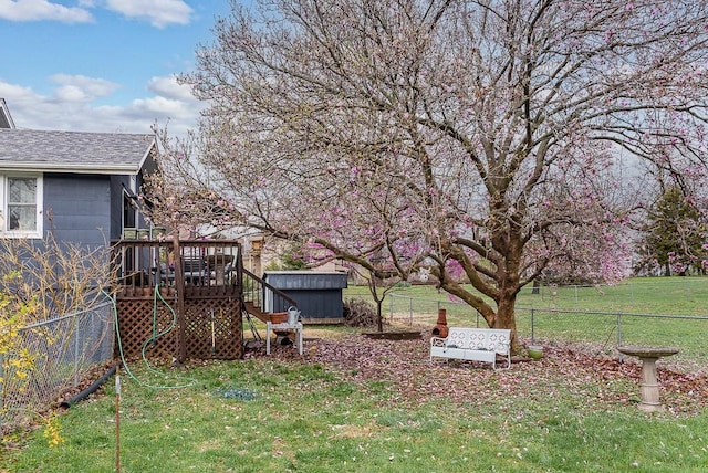 view of yard featuring an outdoor structure, a fenced backyard, stairway, and a deck