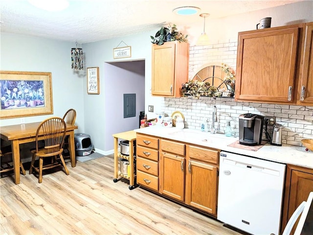 kitchen with a sink, light countertops, decorative backsplash, and dishwasher