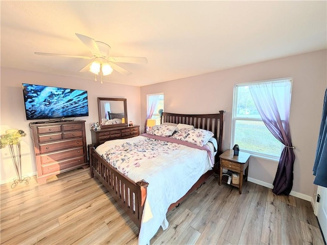 bedroom featuring baseboards, a ceiling fan, and light wood-style flooring