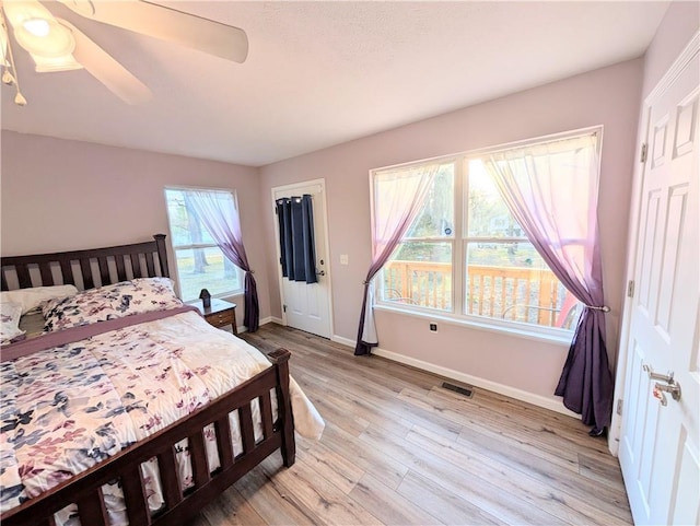 bedroom featuring baseboards, ceiling fan, light wood-style flooring, and visible vents
