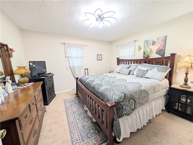 bedroom featuring light carpet and a textured ceiling