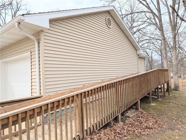 view of home's exterior with a garage and a wooden deck