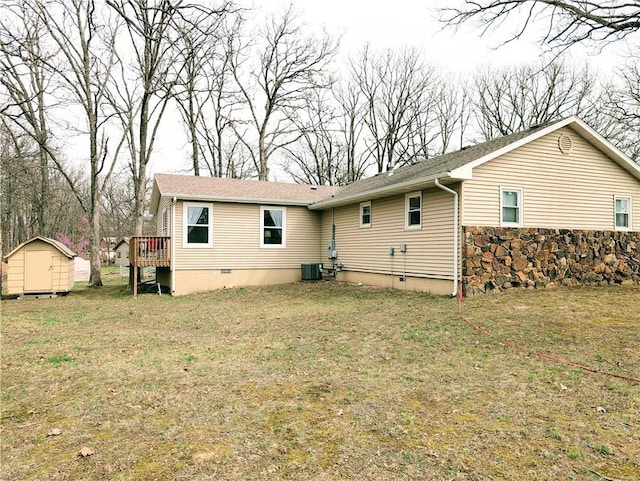 back of property with an outdoor structure, a deck, a shed, crawl space, and central air condition unit