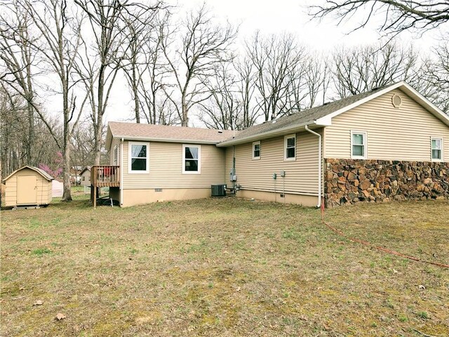 1804 S Phillips St, El Dorado Springs, MO 64744 - back of property with an outdoor structure, a deck, a shed, crawl space, and central air condition unit