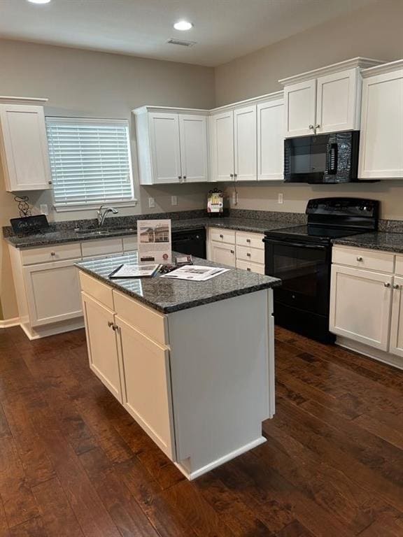 kitchen featuring white cabinetry, a sink, dark wood-type flooring, and black appliances