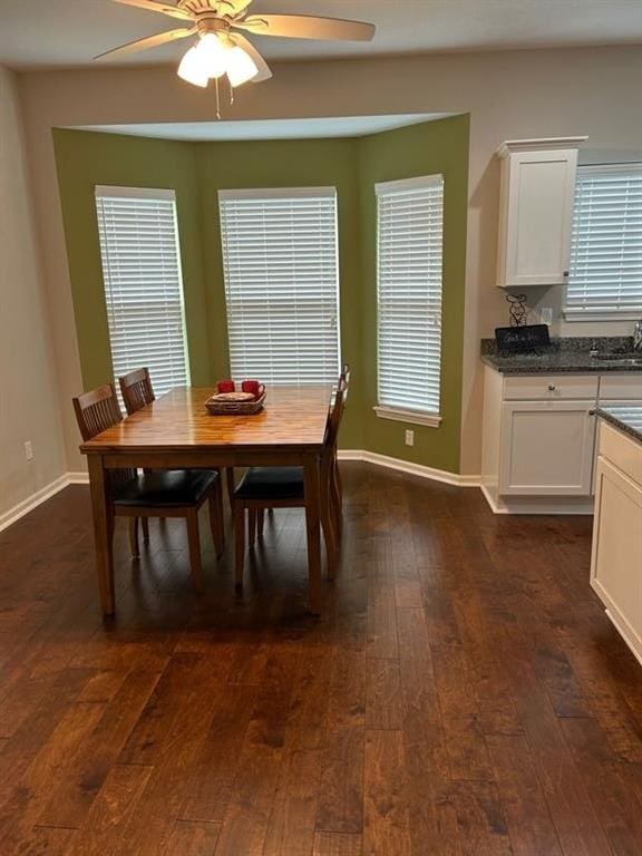 dining area with dark wood-style floors, ceiling fan, and baseboards