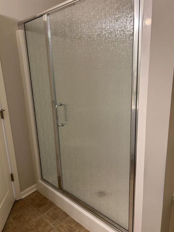 bathroom featuring tile patterned floors and a shower stall