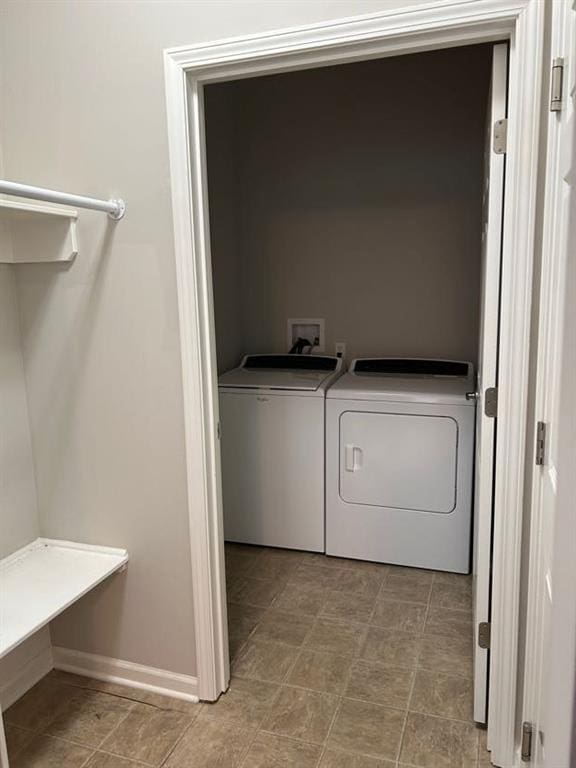 washroom featuring independent washer and dryer, laundry area, and baseboards
