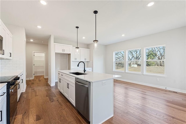 503 Woodview Dr, Raymore, MO 64083 - kitchen featuring stainless steel dishwasher, black range with electric cooktop, a sink, baseboards, and tasteful backsplash