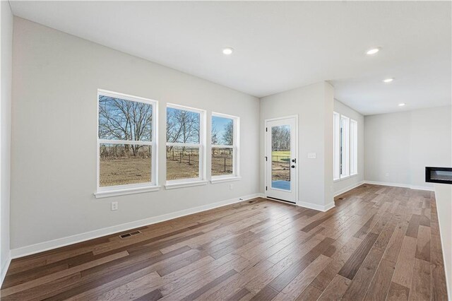 503 Woodview Dr, Raymore, MO 64083 - unfurnished living room with wood finished floors, recessed lighting, and baseboards
