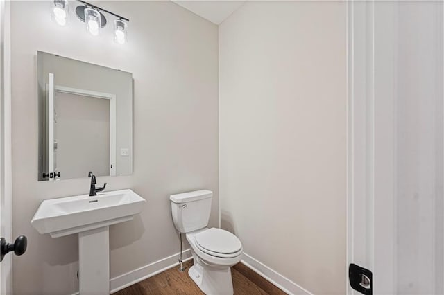 503 Woodview Dr, Raymore, MO 64083 - bathroom featuring toilet, baseboards, and wood finished floors