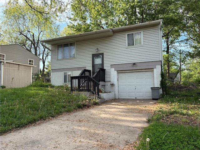 split foyer home with brick siding, an attached garage, and driveway