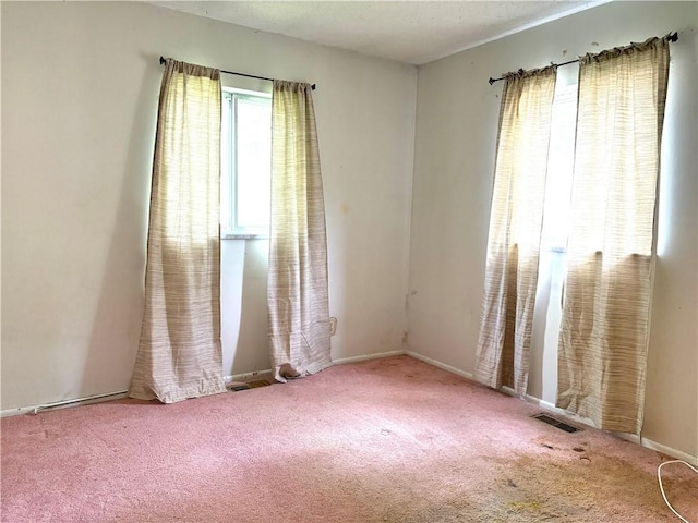 spare room with baseboards, carpet, and visible vents