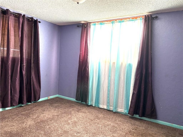 unfurnished room featuring carpet flooring, a textured ceiling, and a textured wall