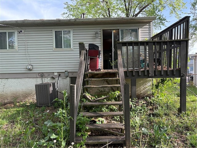 rear view of property featuring cooling unit and a deck