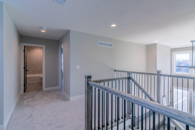 935 168th Ter, Basehor, KS 66007 - hall with an upstairs landing, light colored carpet, baseboards, and recessed lighting