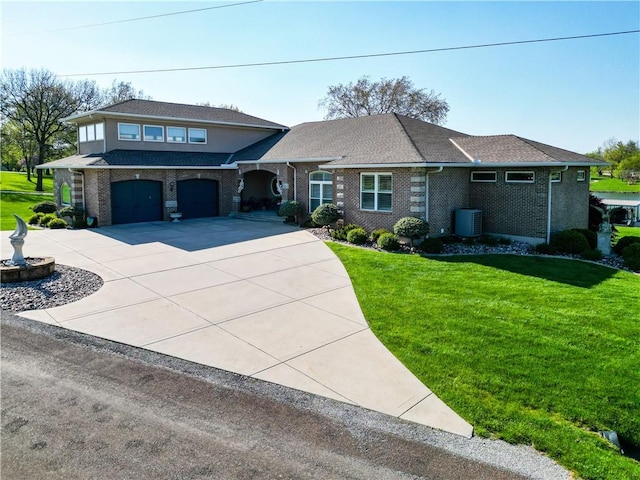 view of front of house with brick siding, an attached garage, a front yard, and central AC unit