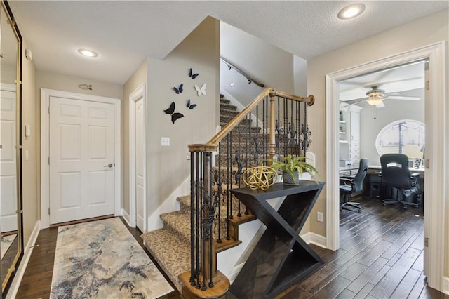 foyer featuring stairway, a ceiling fan, wood finished floors, a textured ceiling, and baseboards