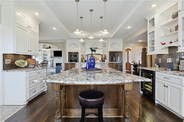 kitchen featuring white cabinets, beverage cooler, high end refrigerator, arched walkways, and dark wood-style flooring