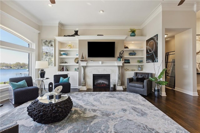 living area with recessed lighting, a high end fireplace, ornamental molding, baseboards, and dark wood-style flooring