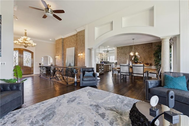 living room with hardwood / wood-style flooring, arched walkways, ceiling fan with notable chandelier, and ornate columns