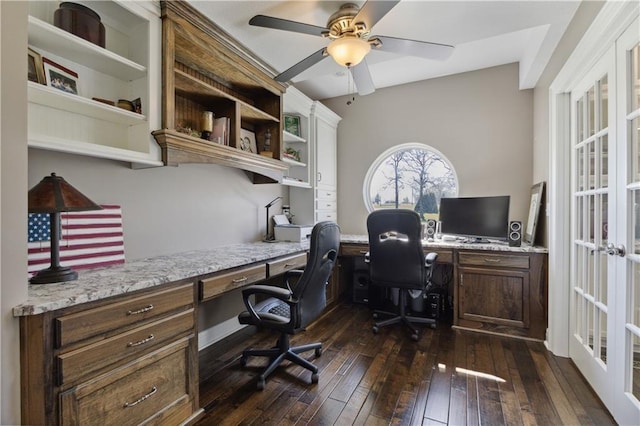 home office featuring built in desk, dark wood finished floors, a ceiling fan, and french doors