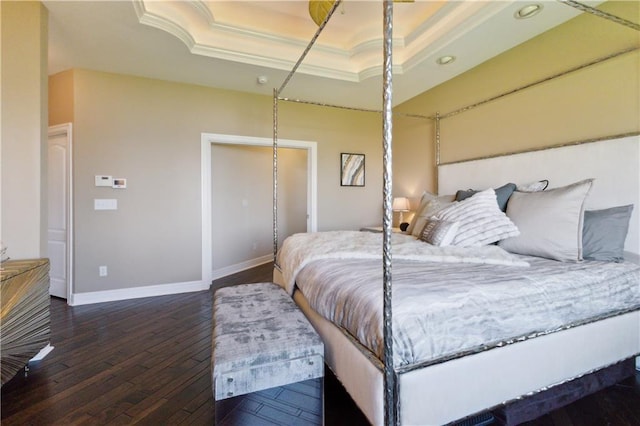 bedroom with a tray ceiling, baseboards, ornamental molding, dark wood-style floors, and recessed lighting